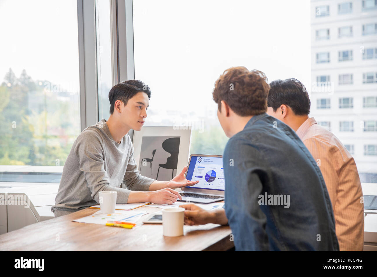 Portrait of three businessmen having a meeting at office Stock Photo