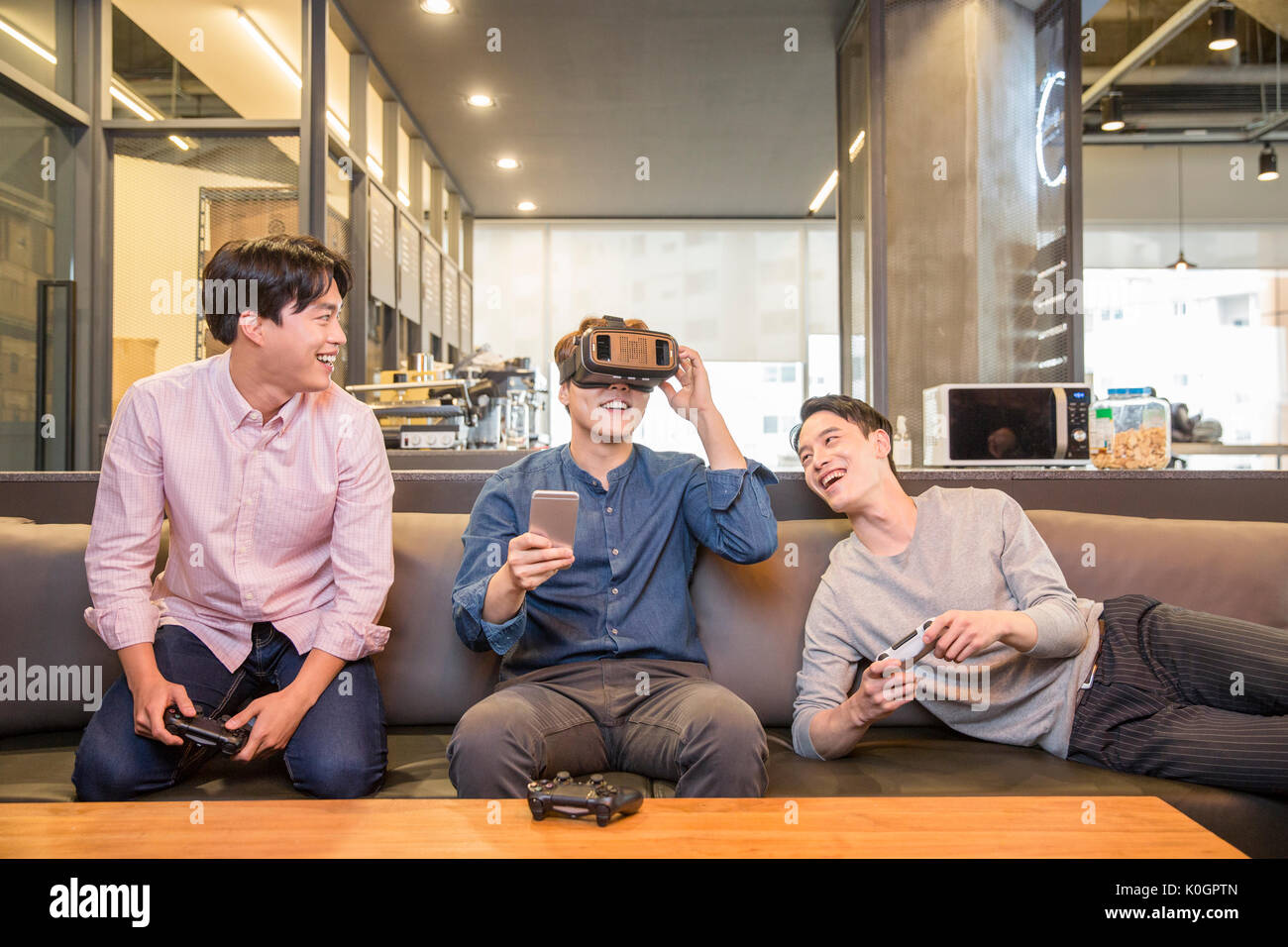 Three smiling businessmen enjoying virtual reality games Stock Photo