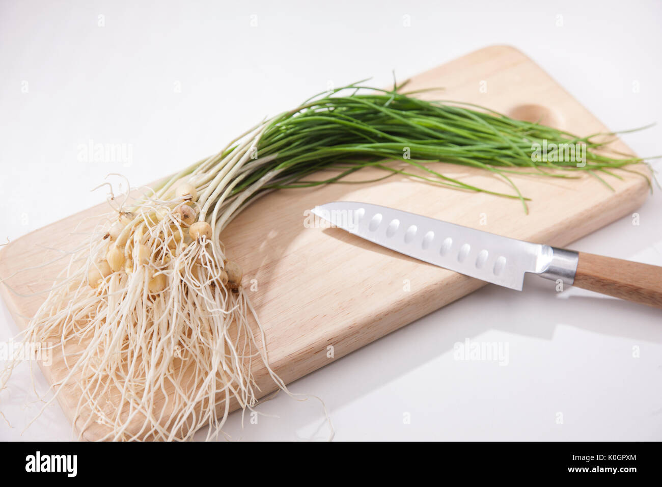 Fresh spring vegetable and kitchen knife on chopping board Stock Photo