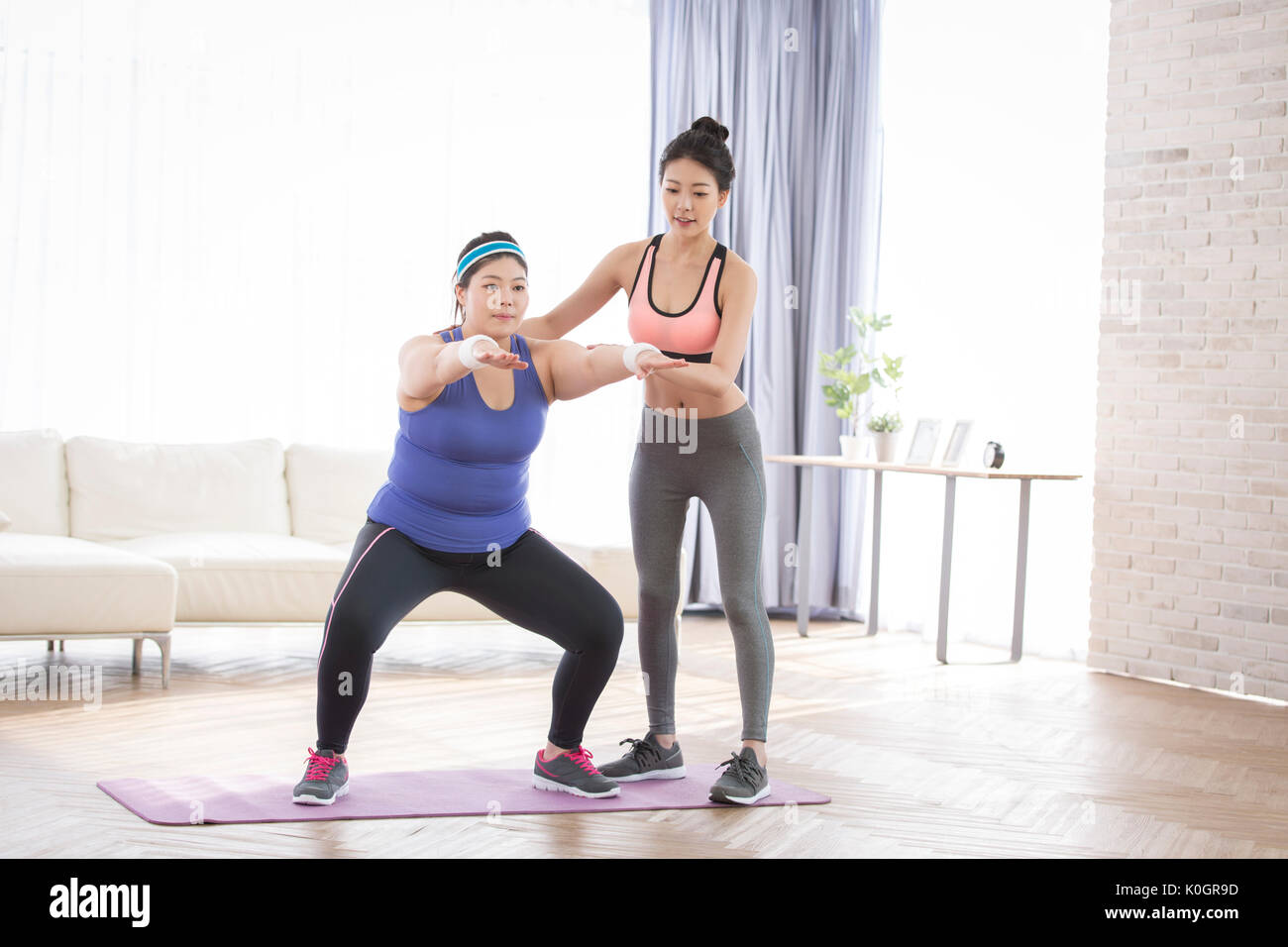 Young smiling female trainer and young fat female trainee Stock Photo ...