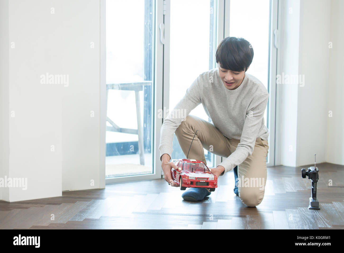 Smiling man kidult playing with toy car Stock Photo