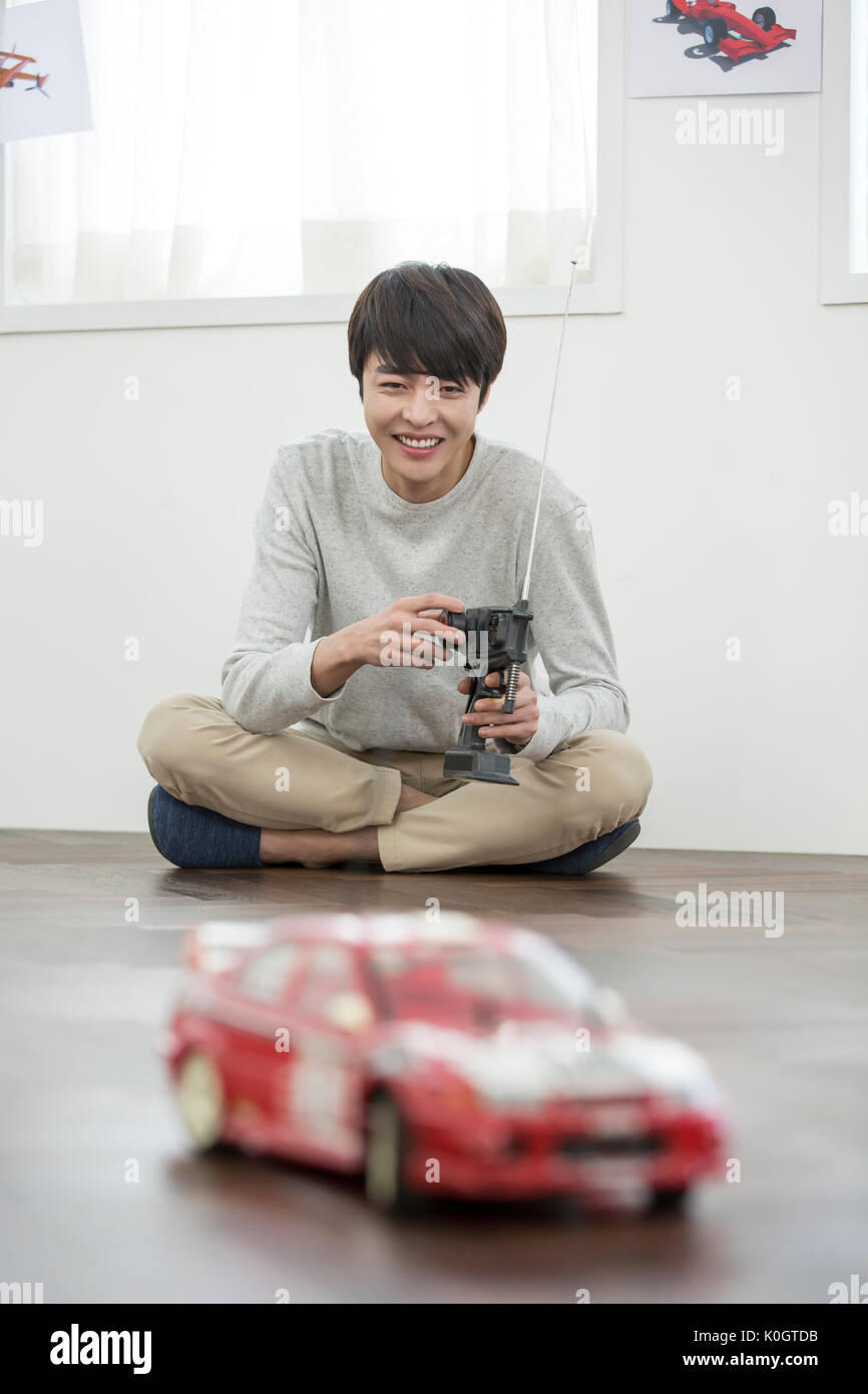 Smiling male kidult playing with toy car Stock Photo
