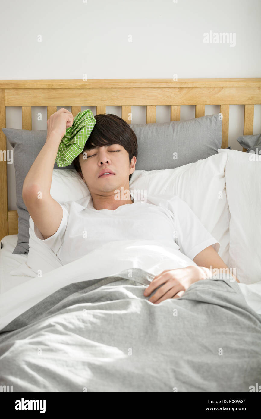 Single man sick putting an ice pack on his head Stock Photo Alamy