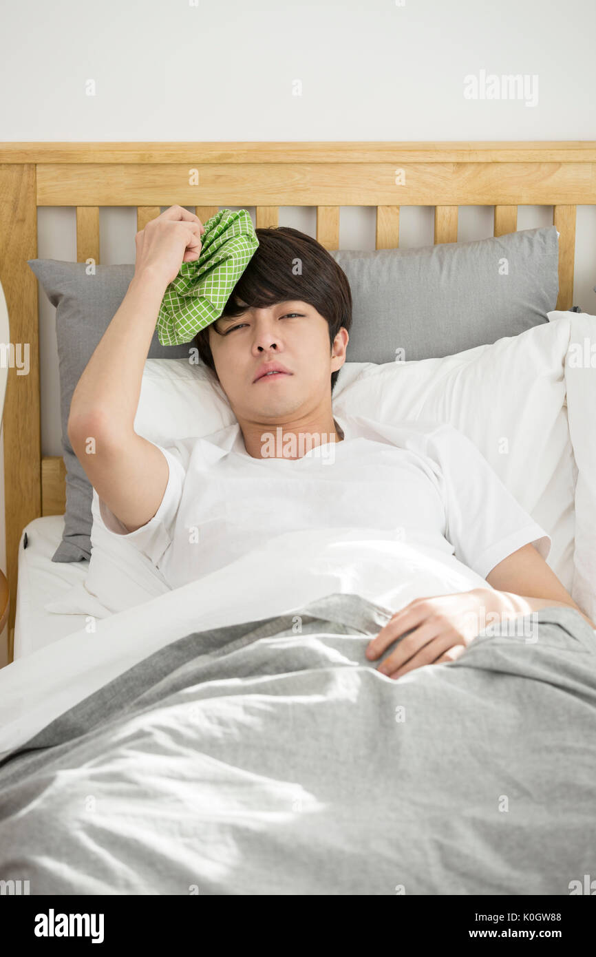 Single man sick putting an ice pack on his head Stock Photo Alamy