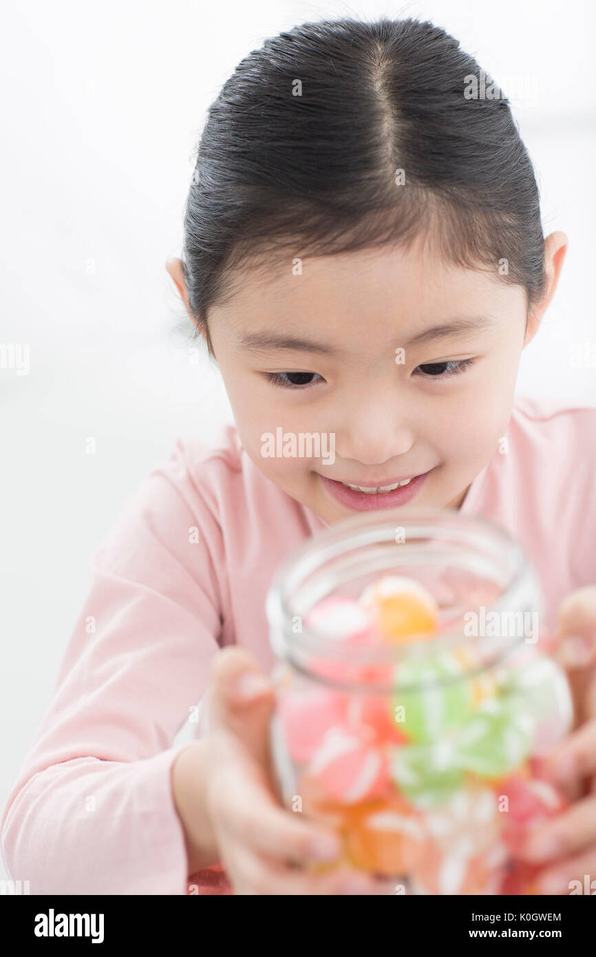 Portrait of smiling girl with a jar of candy Stock Photo