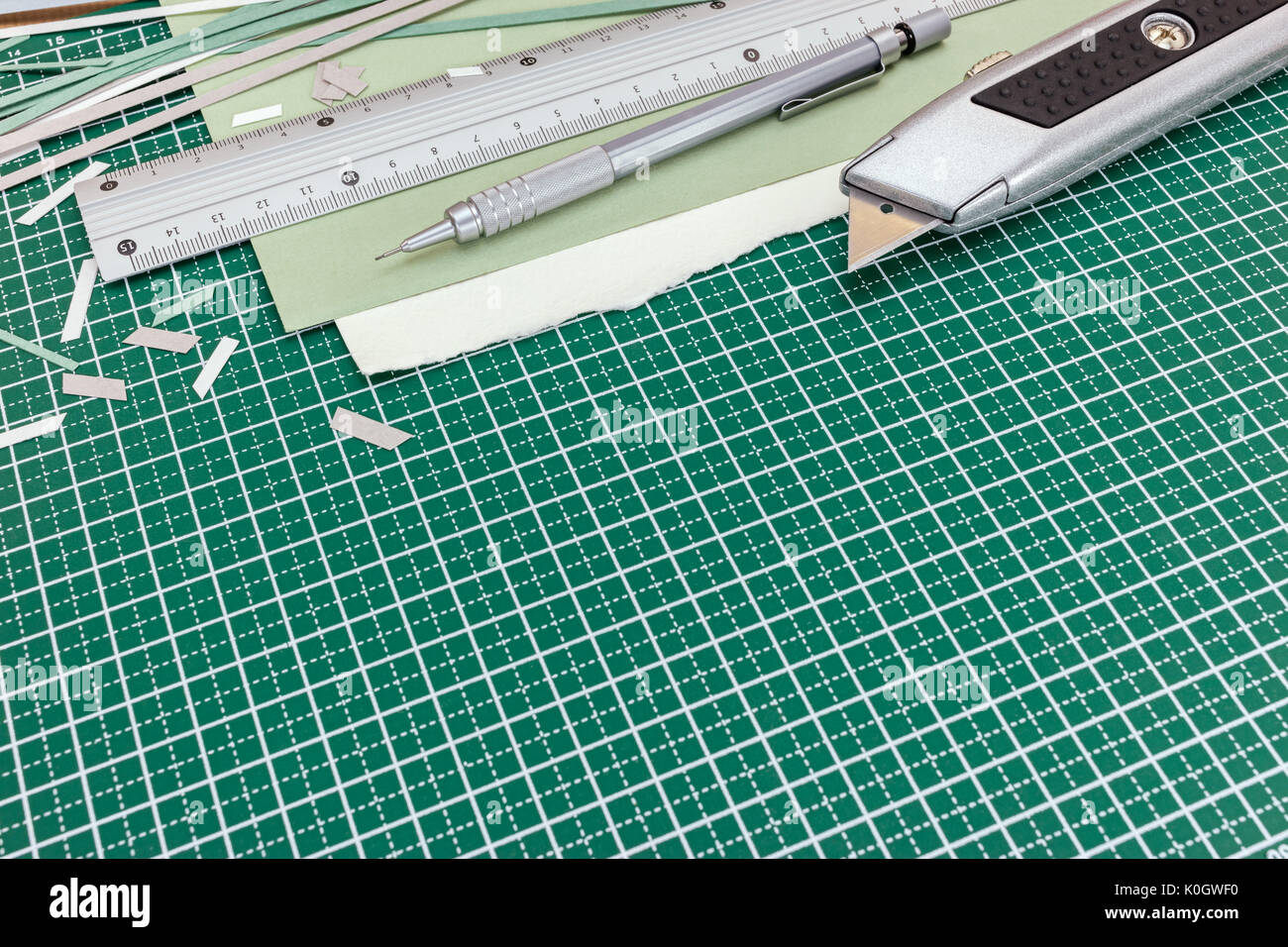 cutting equipment on desk - utility knife, metal ruler with pencil Stock Photo