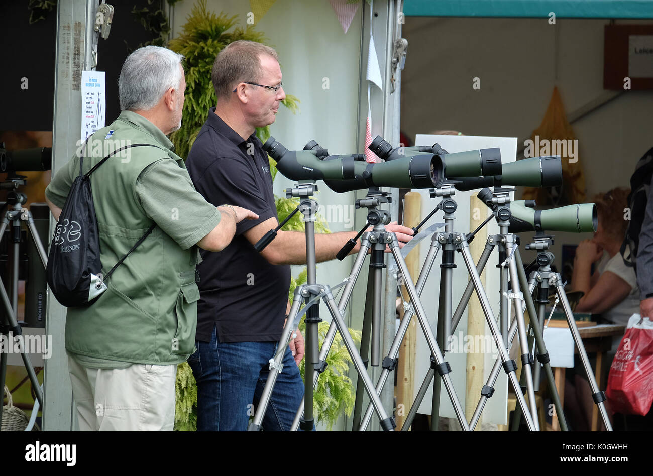 Men looking at sellection of new wildlife nigh magnification spotting scopes. Stock Photo
