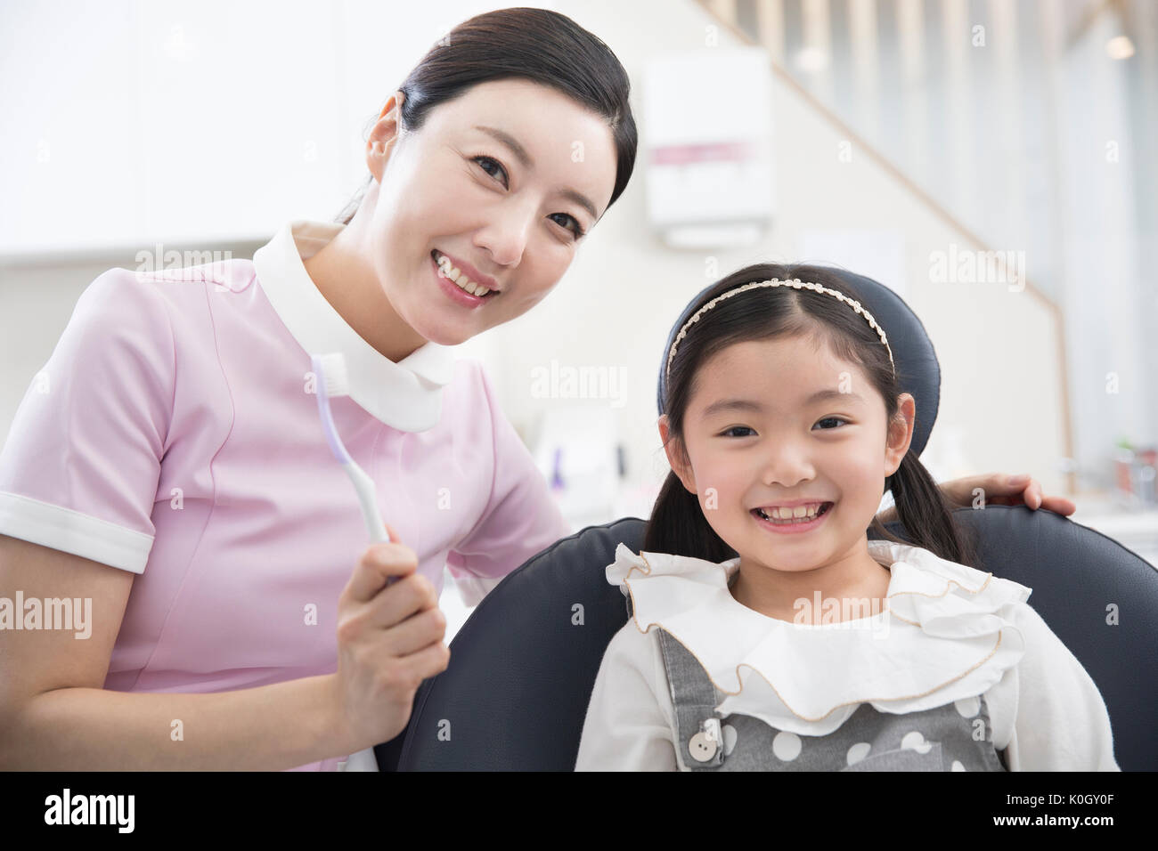 Portrait of smiling dental hygienist and smiling girl patient Stock Photo