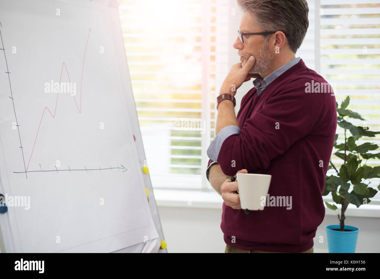 Thoughtful worker looking at a white board Stock Photo