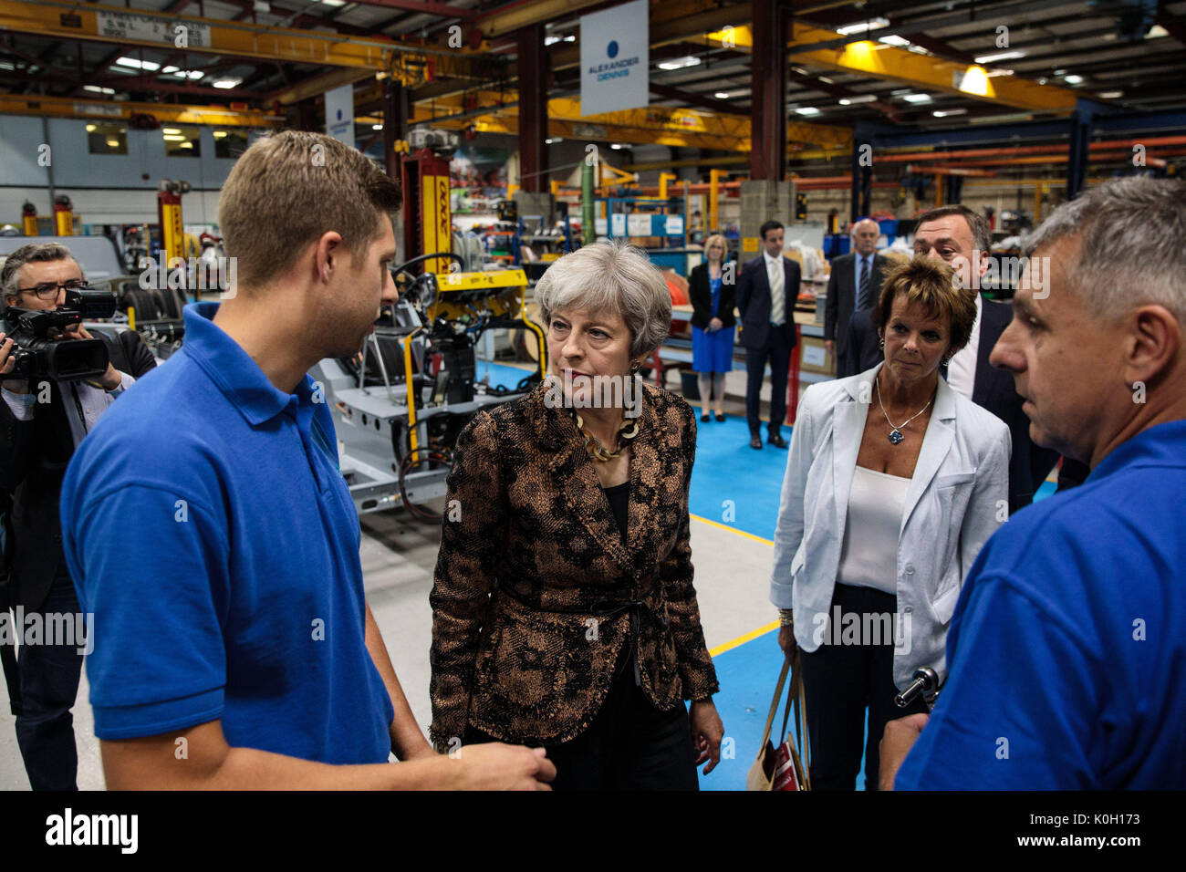 Prime Minister Theresa May (second left) tours the Alexander Dennis bus and coach manufacturers factory in Guildford, Surrey, with local MP Anne Milton (second right). Stock Photo