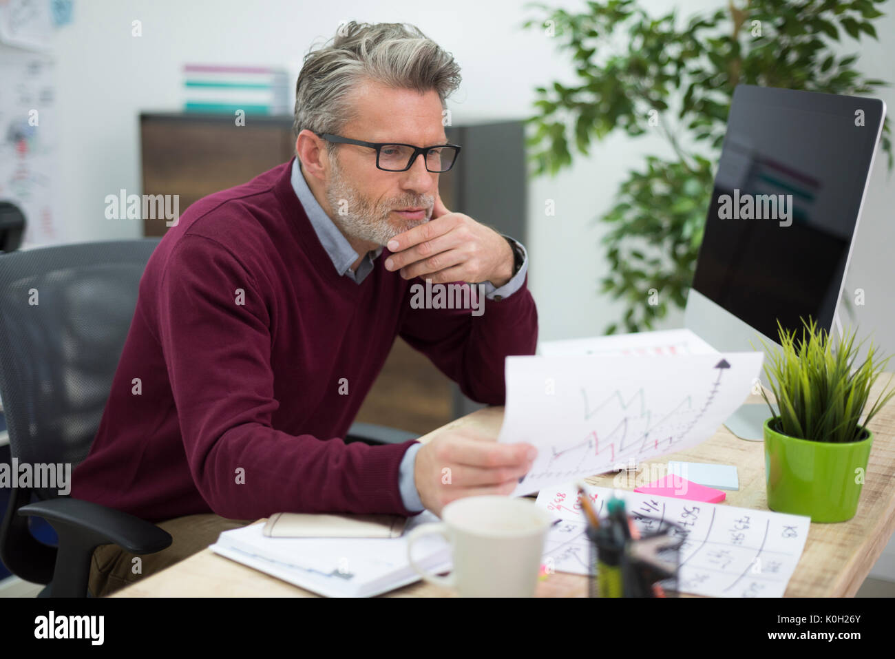 Hardworking man reading some important documents Stock Photo