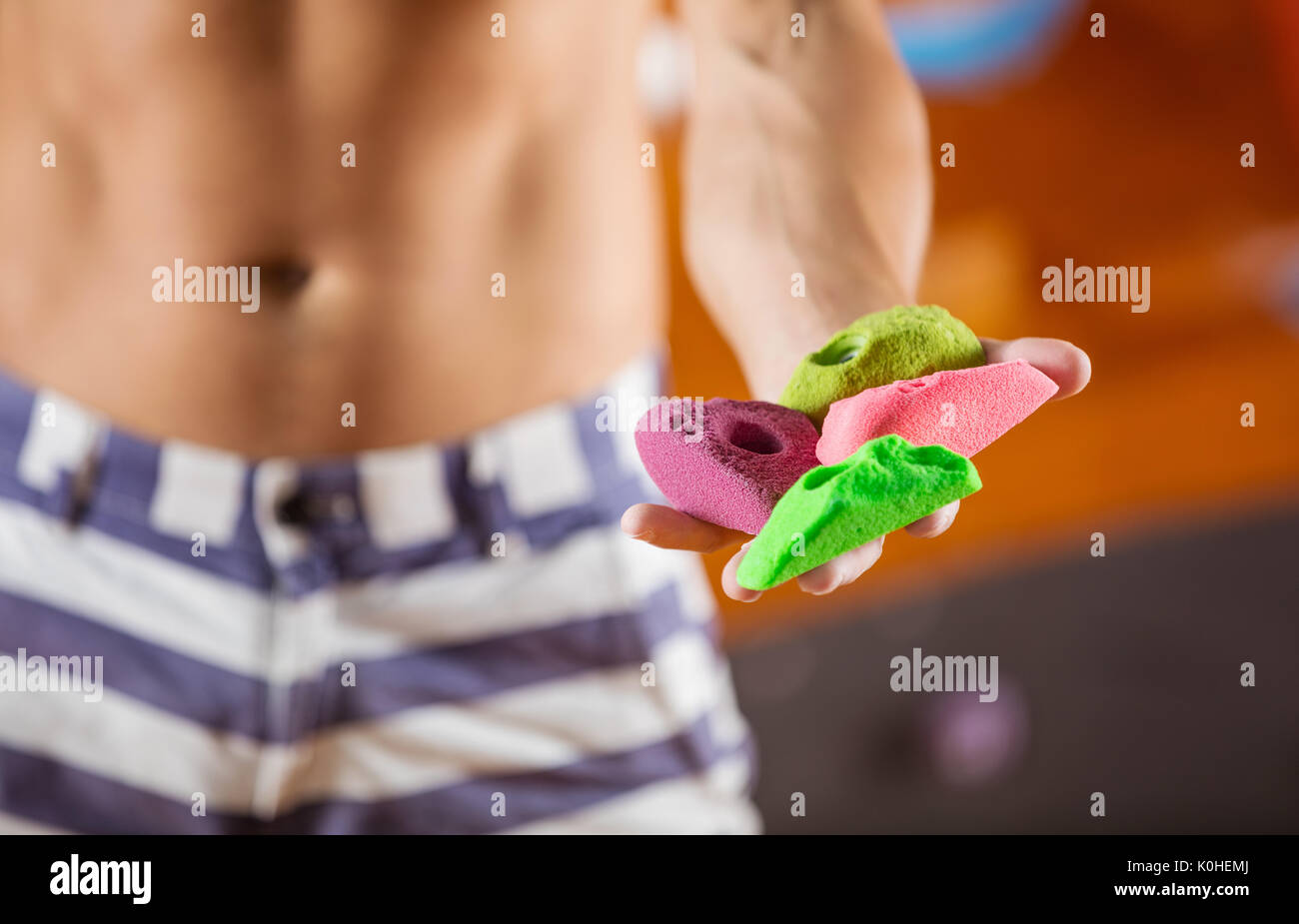 Rock climber demonstrating new bolt-on climbing holds, selective focus Stock Photo