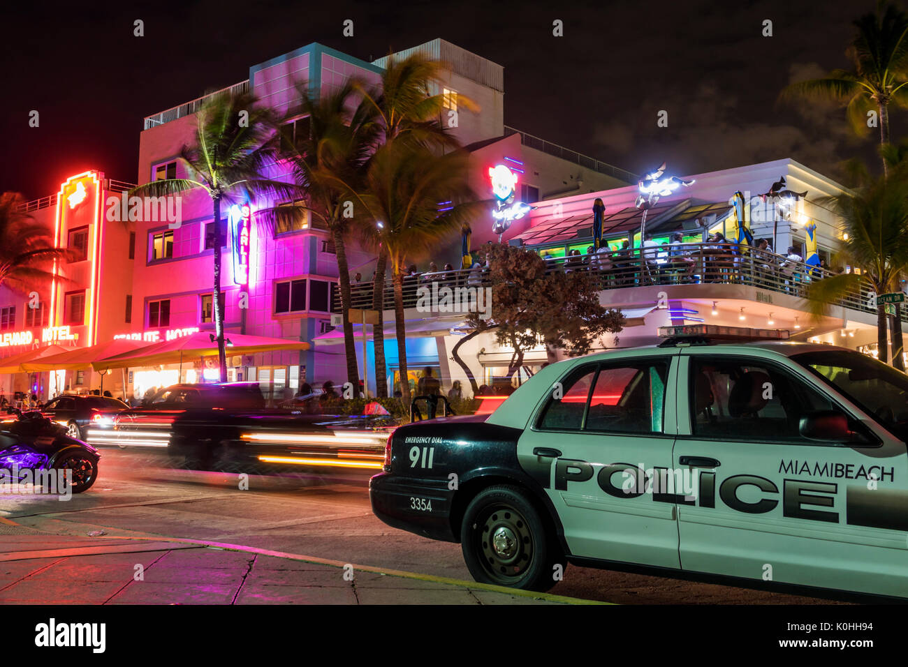 Miami Beach Florida,Ocean Drive,night evening Lummus Park,hotels,neon signs,lighting,palm trees,police car,Starlite,hotel,Wet Willie's,FL170430101 Stock Photo
