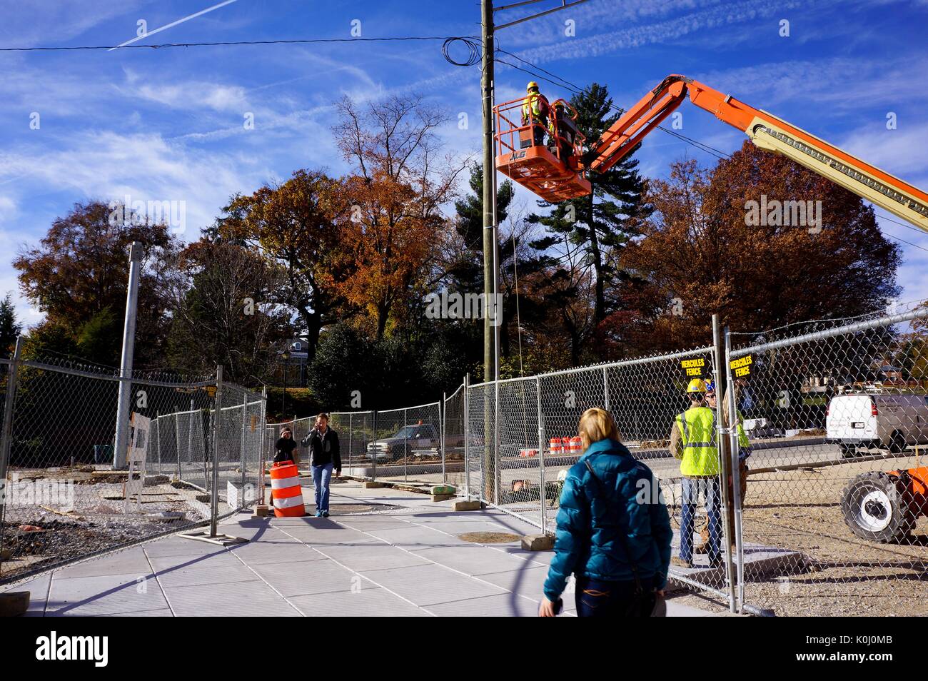 College students cross Charles street, where construction is being done to improve the area for pedestrians and drivers, by the Homewood campus of the Johns Hopkins University in Baltimore, Maryland, 2015. Courtesy Eric Chen. Stock Photo