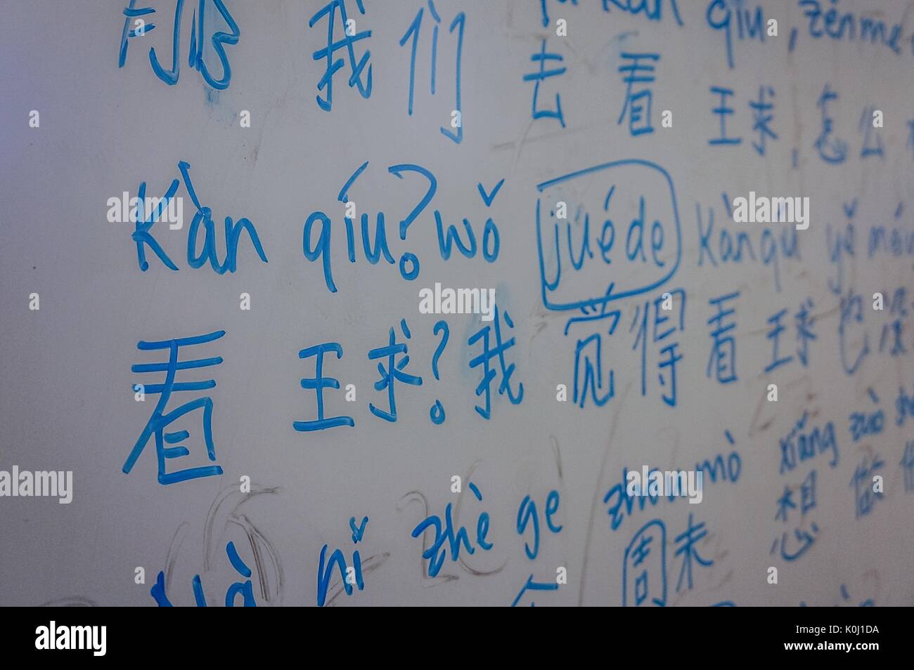 Chinese characters and their transliteration on a whiteboard in blue marker, 2016. Courtesy Eric Chen. Stock Photo