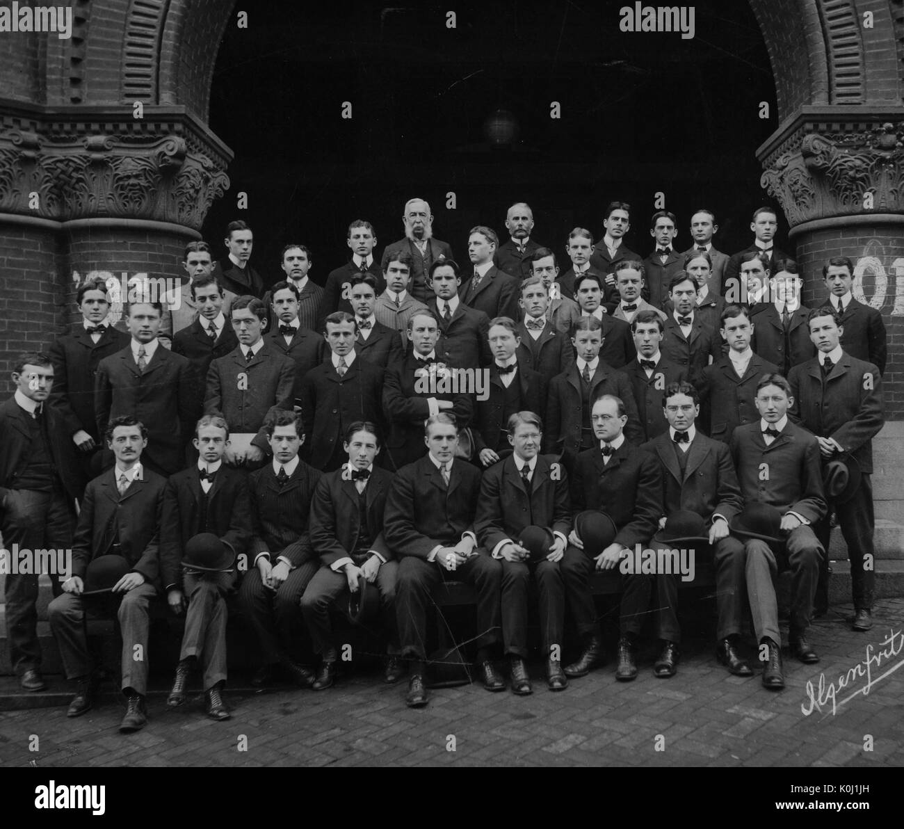 Group portrait of the Johns Hopkins University class of 1901, gathered on the steps to a large brick building in Baltimore, Maryland. 1901. Stock Photo