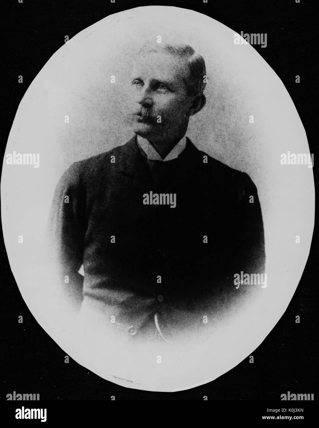 Half-length photograph of physiology professor at Johns Hopkins, Henry Newell Martin, wearin ga dark jacket and a white shirt, with his arms behind his back, posed in front of a backdrop, with his head turned to his right, with a serious facial expression. 1880. Stock Photo