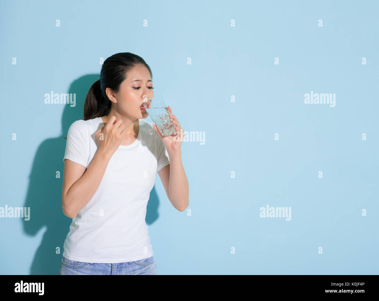 young beautiful female student drinking ice water and worry about ...