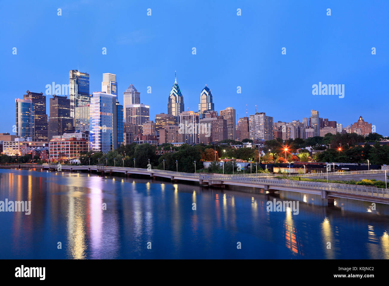 Philadelphia skyline illuminated and reflected into Schuylkill River at dusk, USA Stock Photo