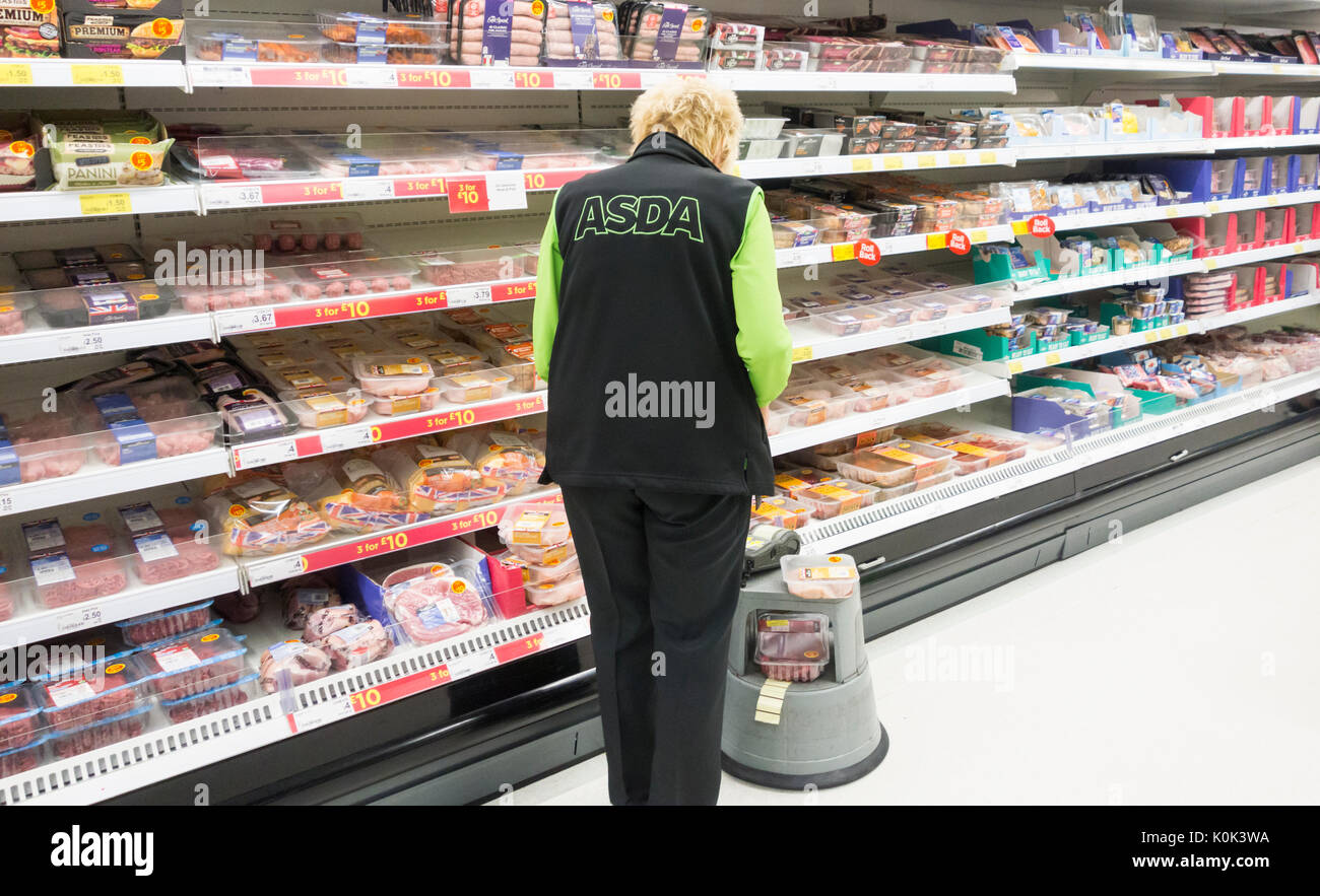 Mature female Asda employee in Asda supermarket. UK Stock Photo