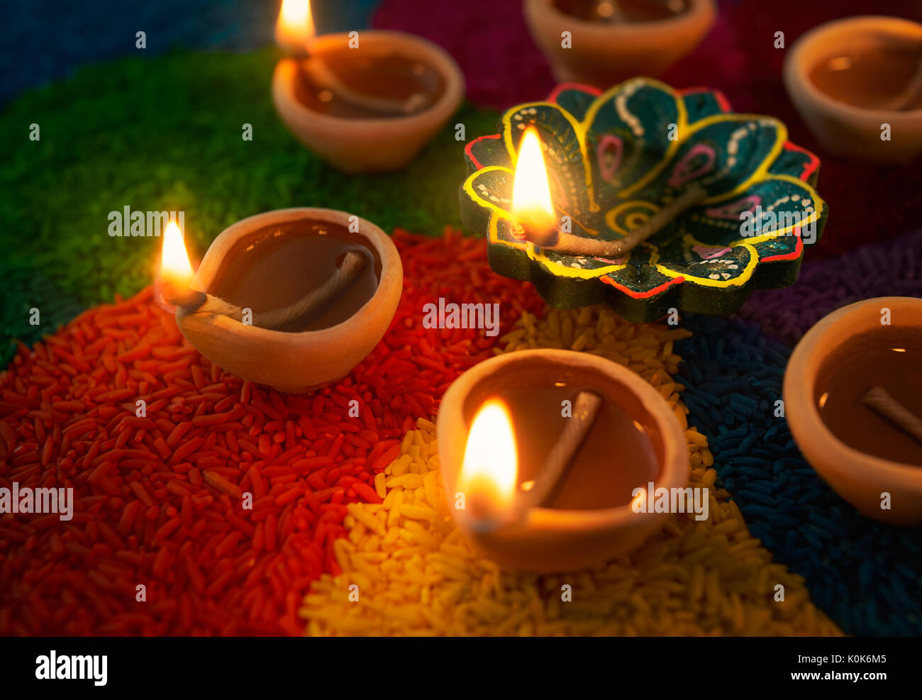 Diwali oil lamp - Diya lamp lit on colorful Rangoli Stock Photo - Alamy
