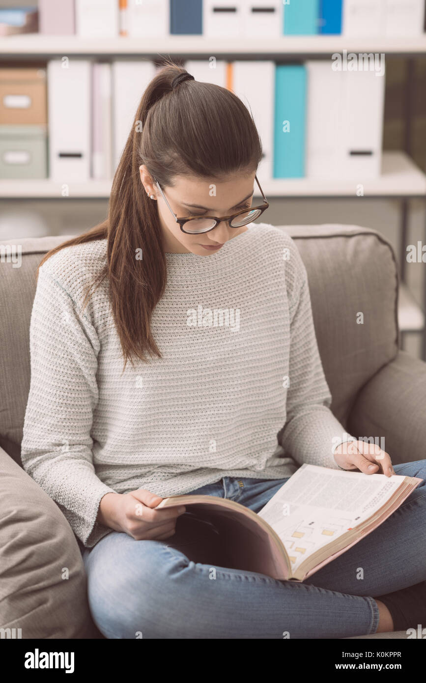 Smart girl with glasses studying at home, she is relaxing on the