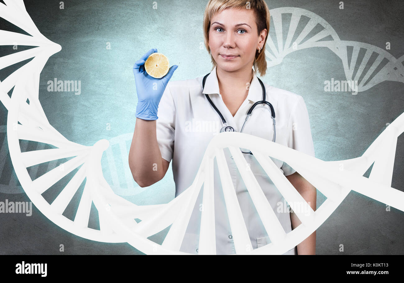 Woman doctor standing among large dna chain. Stock Photo