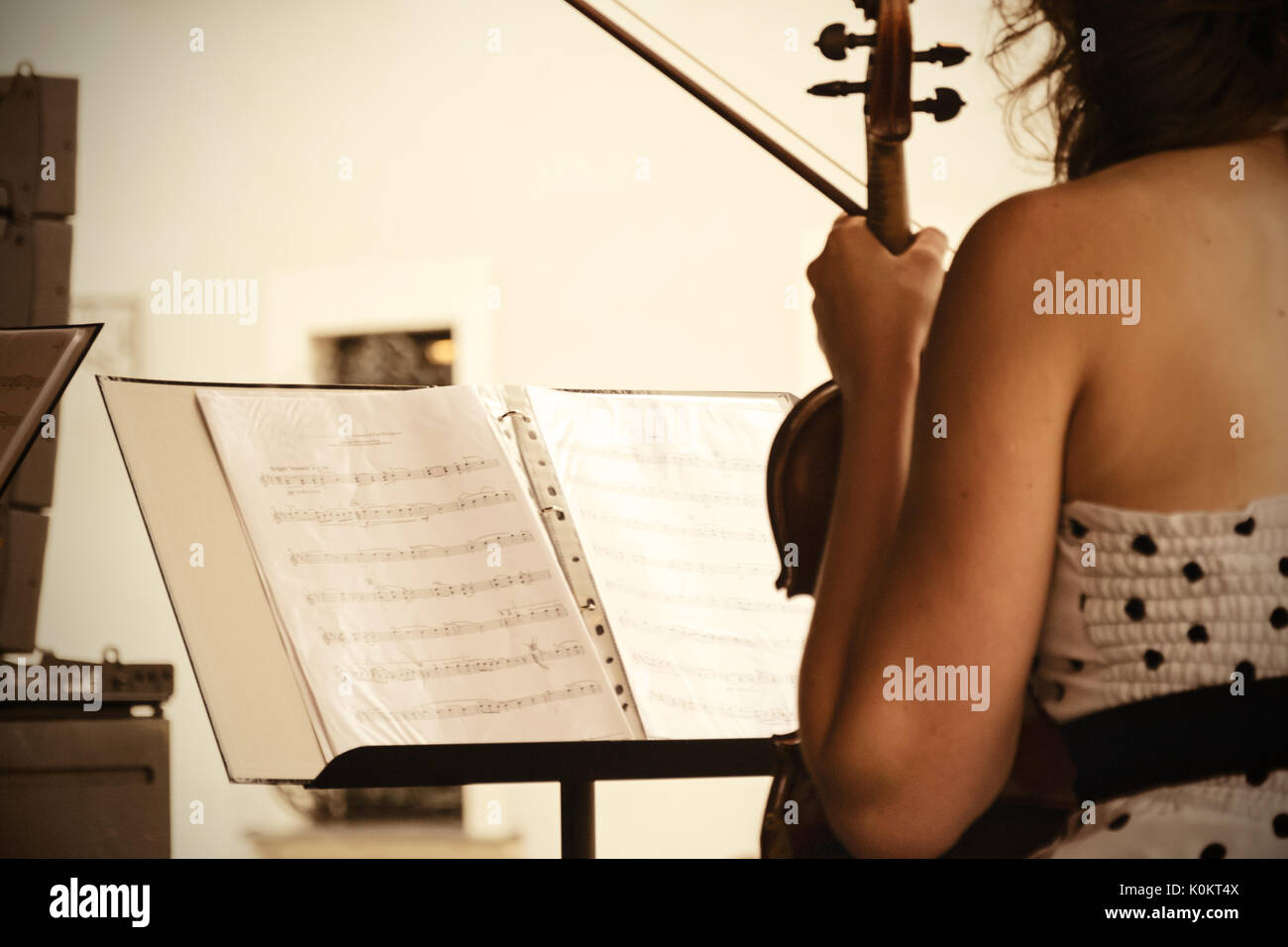 View of the sheet music and the violinist during a concert of classical music in the open air. Stock Photo