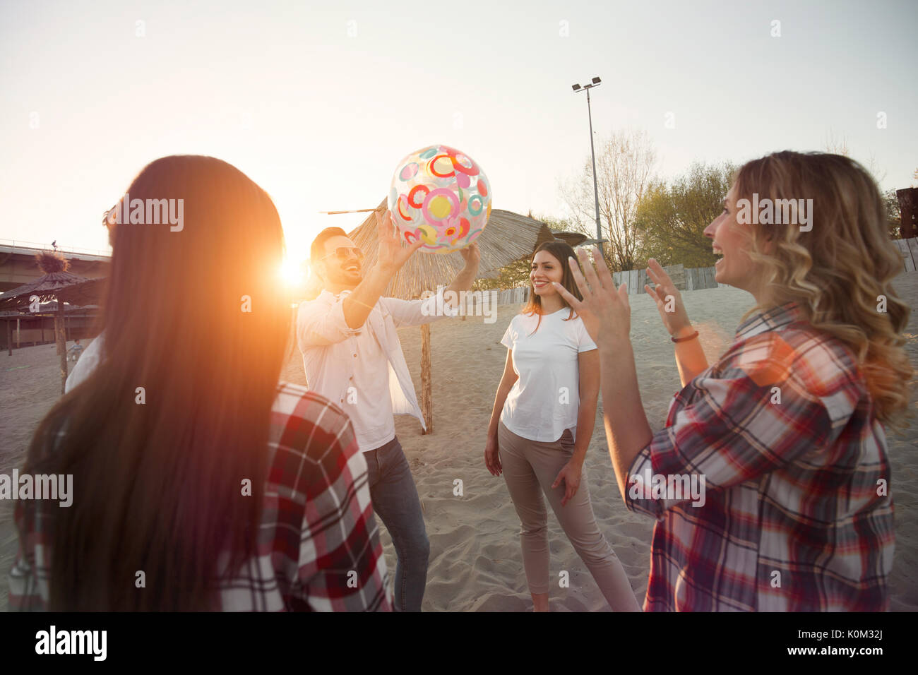 Group of young cheerful friends playing with ball Stock Photo