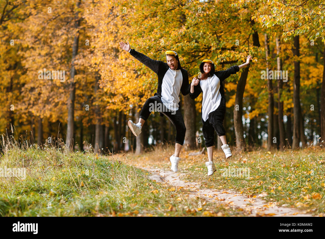 Couple in Matching Penguin Pajamas in autumn forest Stock Photo