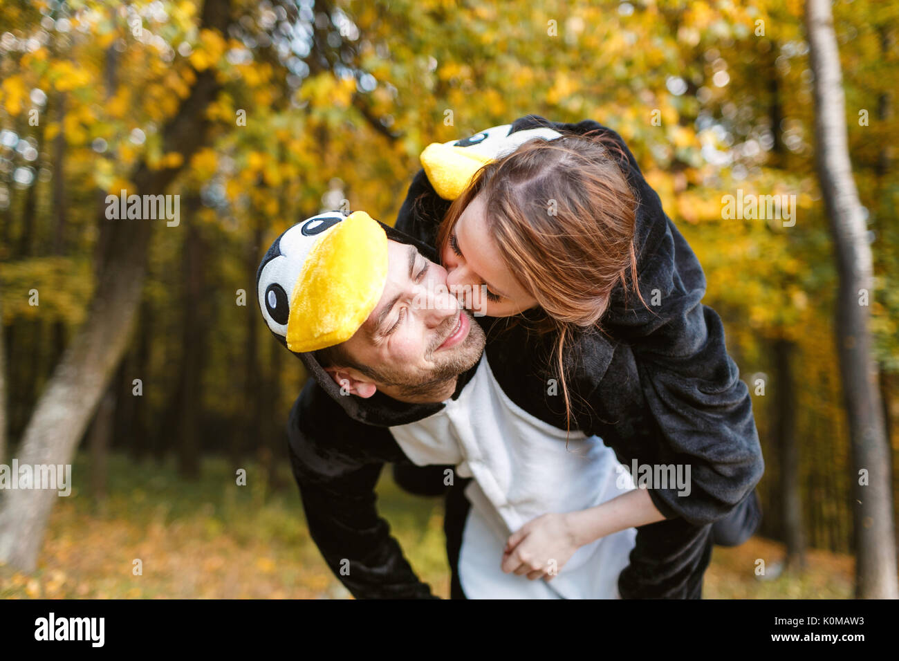 Couple in Matching Penguin Pajamas in autumn forest Stock Photo
