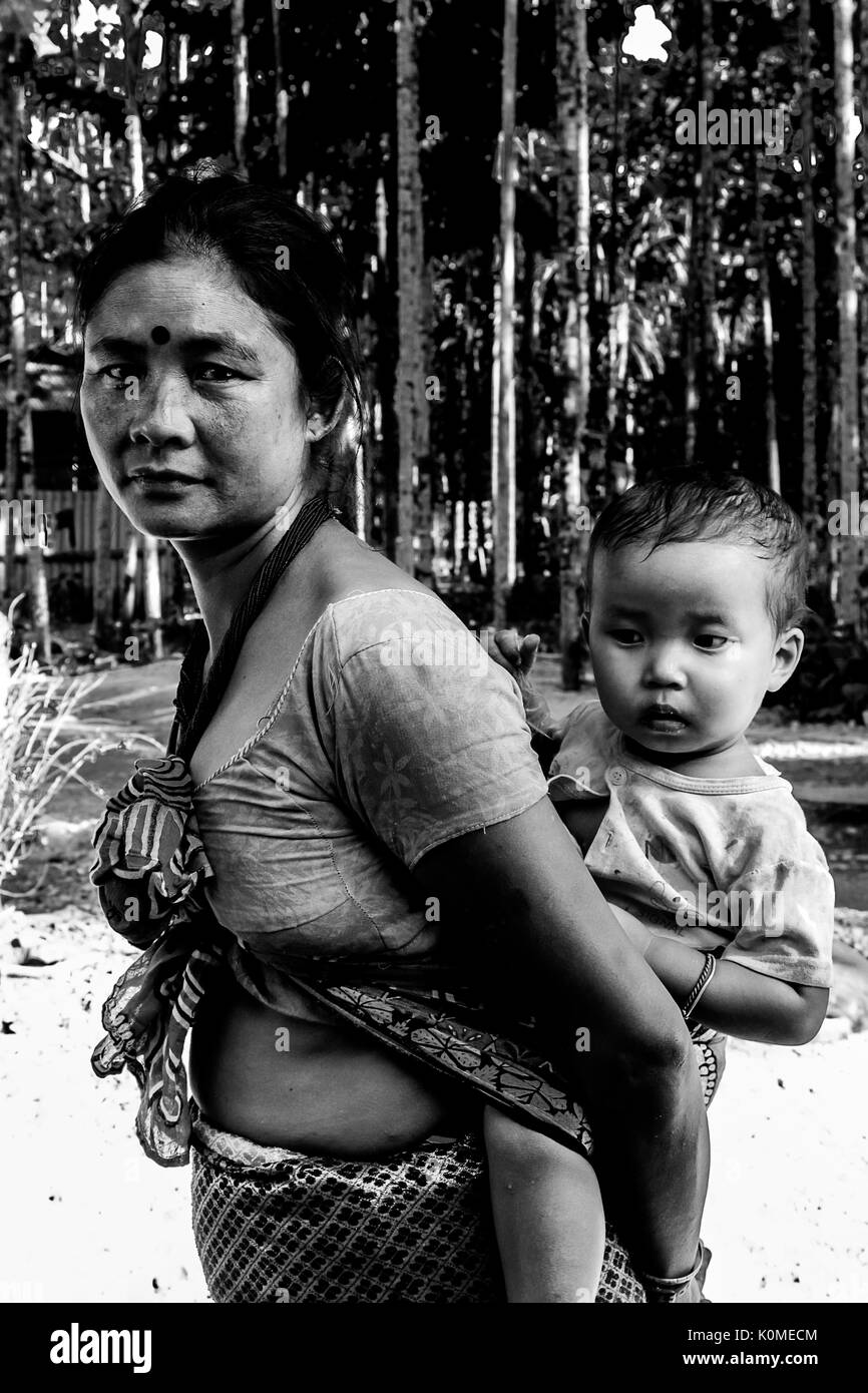 woman carrying child baby on back, Bhutan Stock Photo
