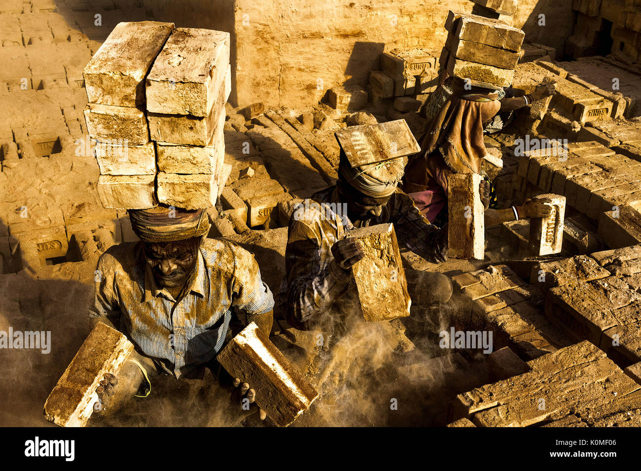 worker carrying bricks on head in factory, India, Asia Stock Photo