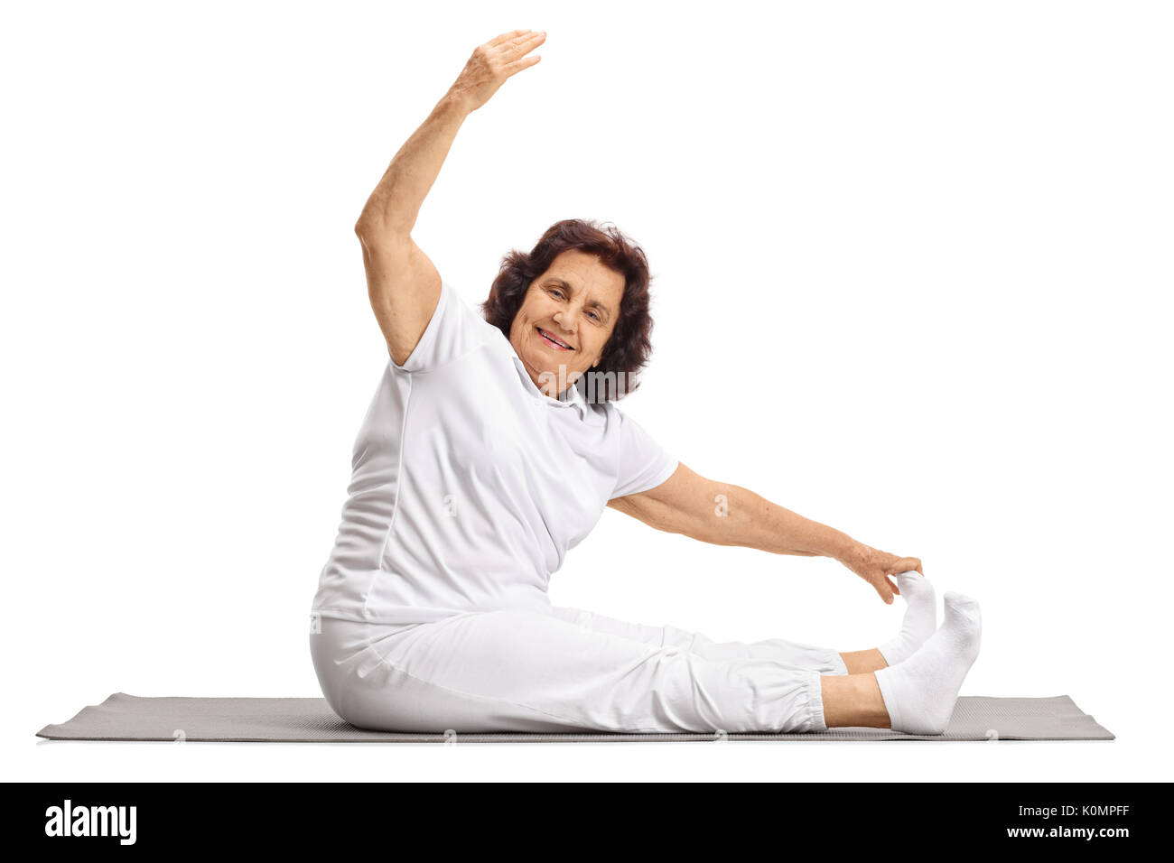 Elderly woman exercising on a mat isolated on white background Stock Photo