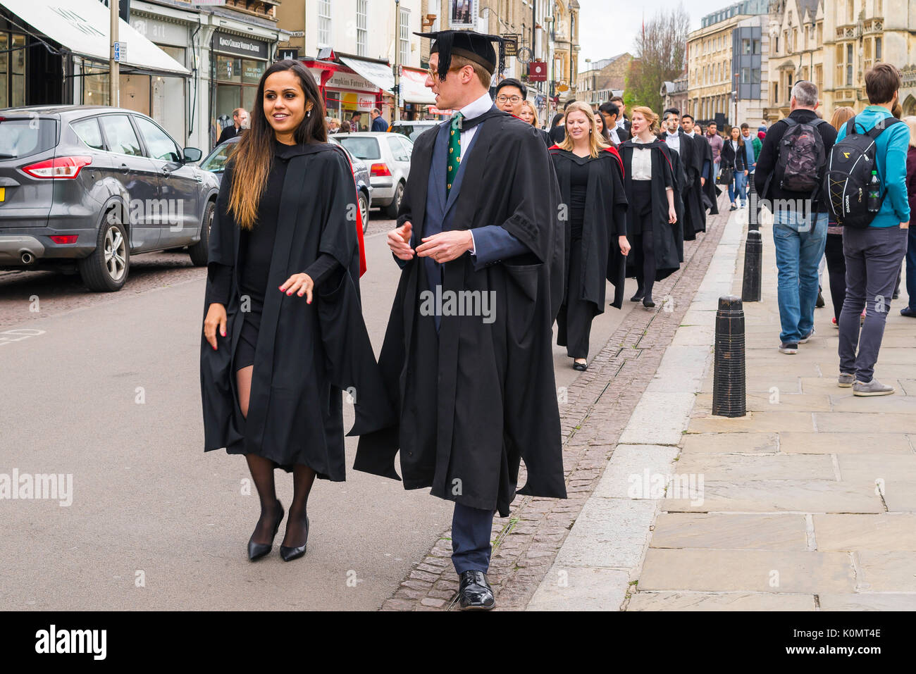 Cambridge students UK, a group of Cambridge University undergraduates walk along King's Parade on their way to their graduation ceremony, England. Stock Photo