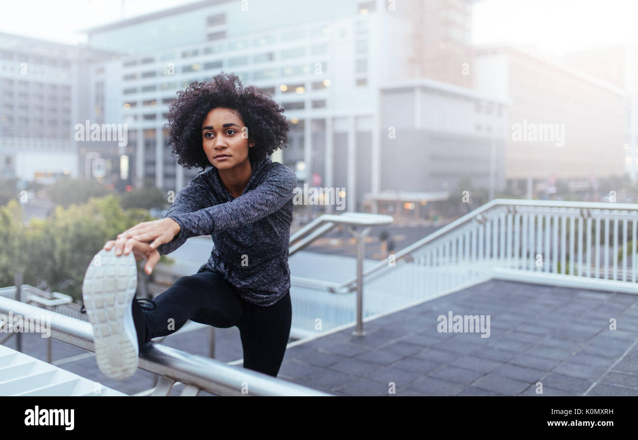 Woman runner doing stretching exercises. Woman using stair railing for ...