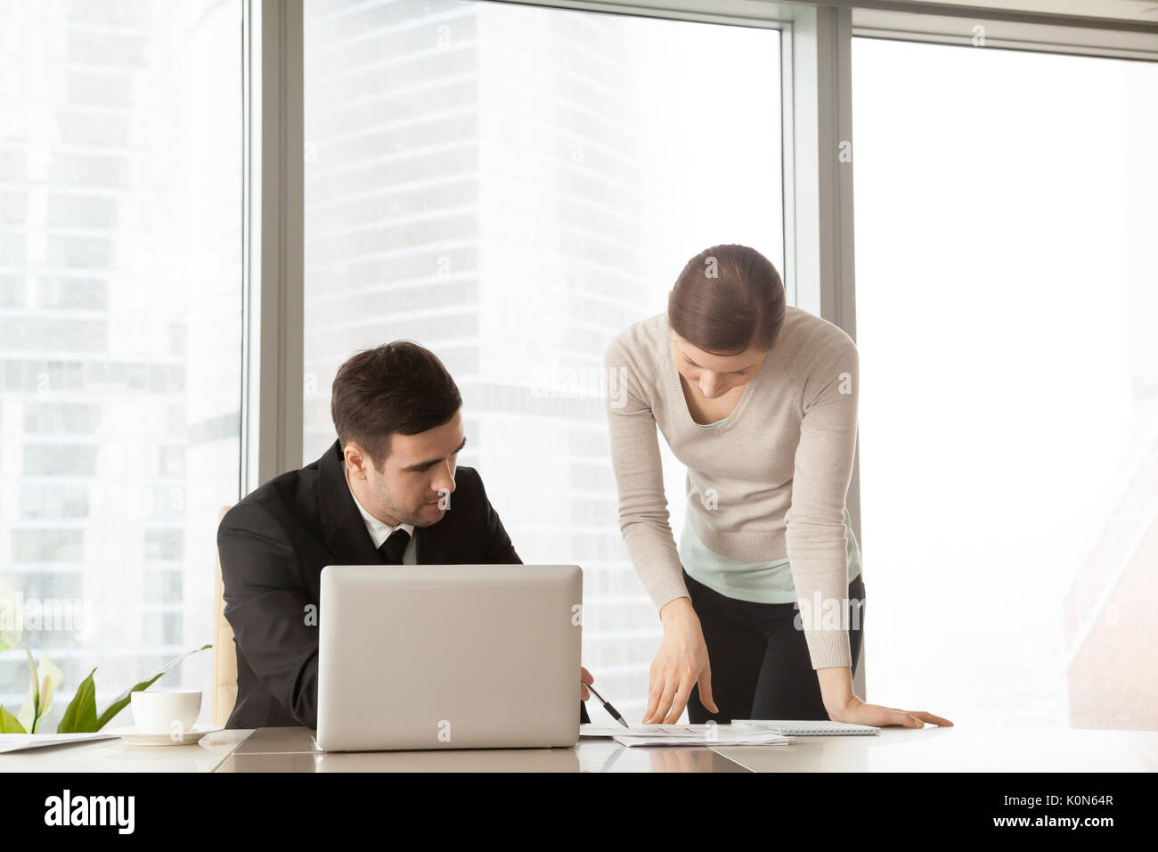 Serious boss explaining project to assistant, architects discuss Stock Photo