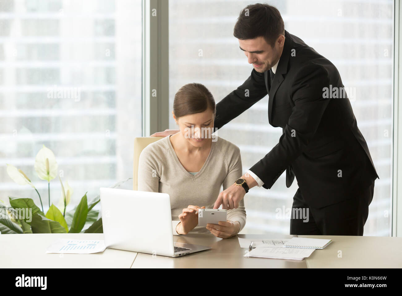 Smiling managers working on tablet, agents using real estate app Stock Photo