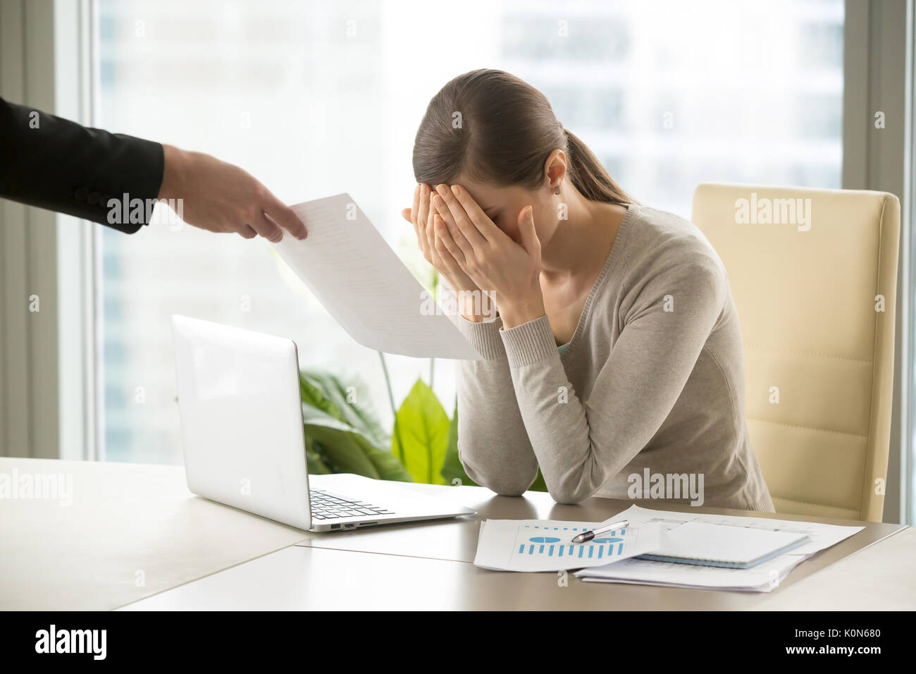 Sad depressed businesswoman gets document with bad news, company Stock Photo