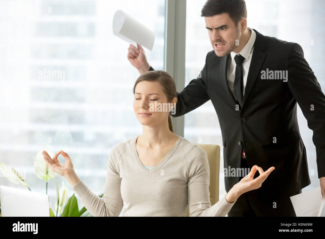 Calm attractive businesswoman meditating in office, ignoring ang Stock Photo