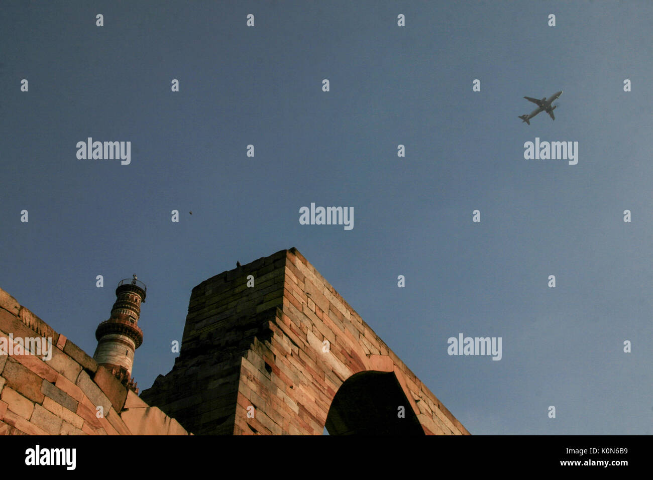 Airplane flying over the Qutb Minar Stock Photo