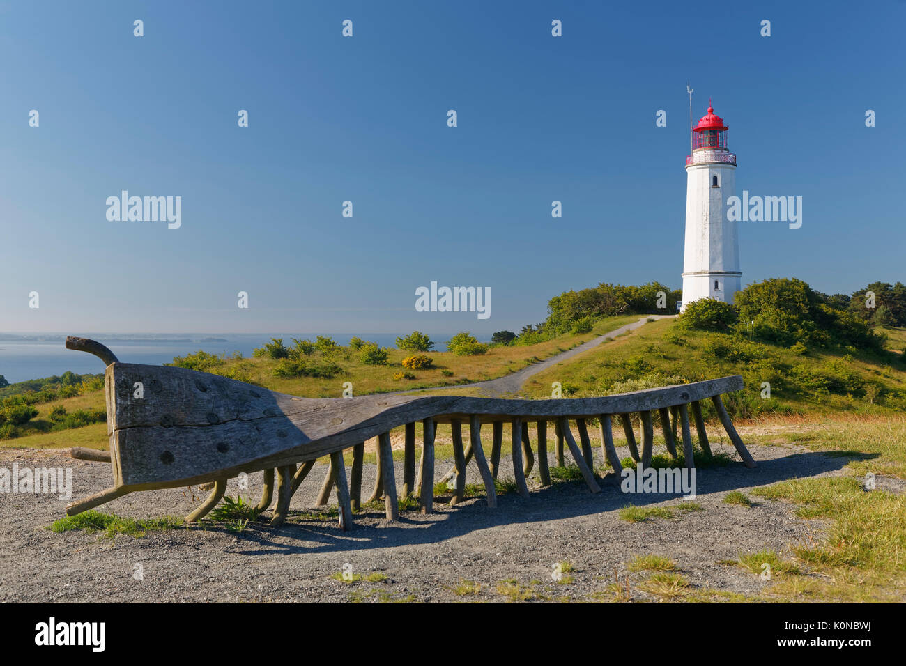 Germany, Mecklenburg-Western Pomerania, Hiddensee, Dornbusch lighthouse on the Schluckswiek, with old twisted wood bench in foreground Stock Photo