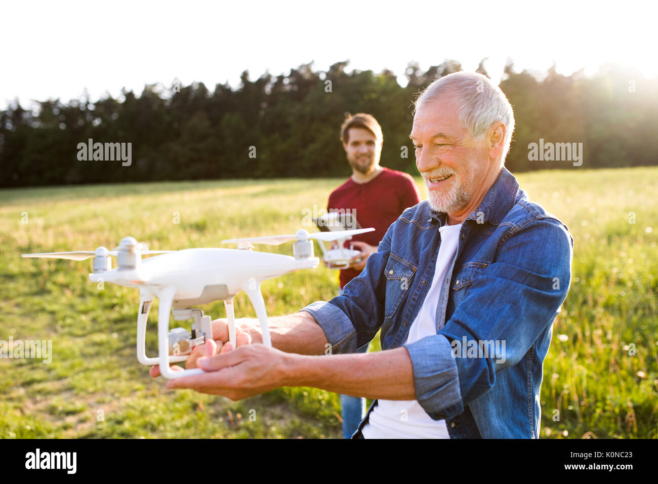 Senior father and his adult son with drone on a meadow Stock Photo - Alamy