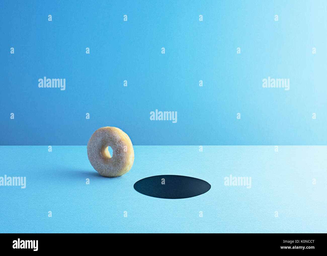 Doughnut and hole on light blue ground Stock Photo