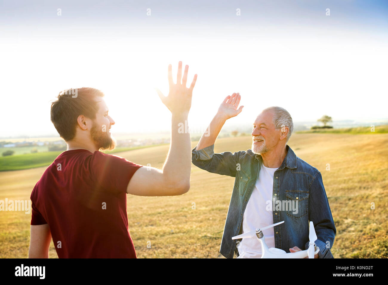 Senior father and his adult son with drone on a field Stock Photo - Alamy
