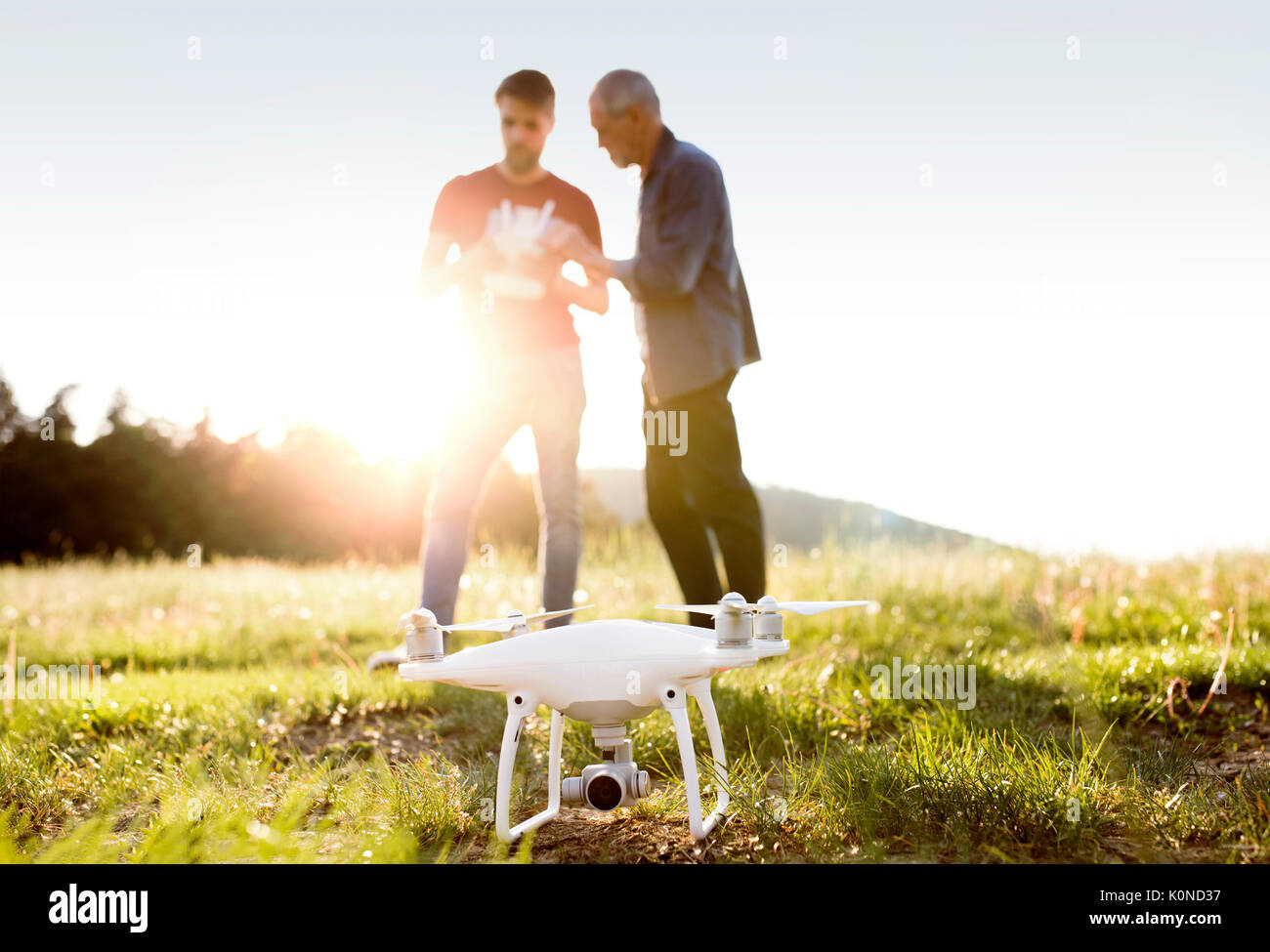 Senior father and his adult son with drone on a meadow Stock Photo - Alamy