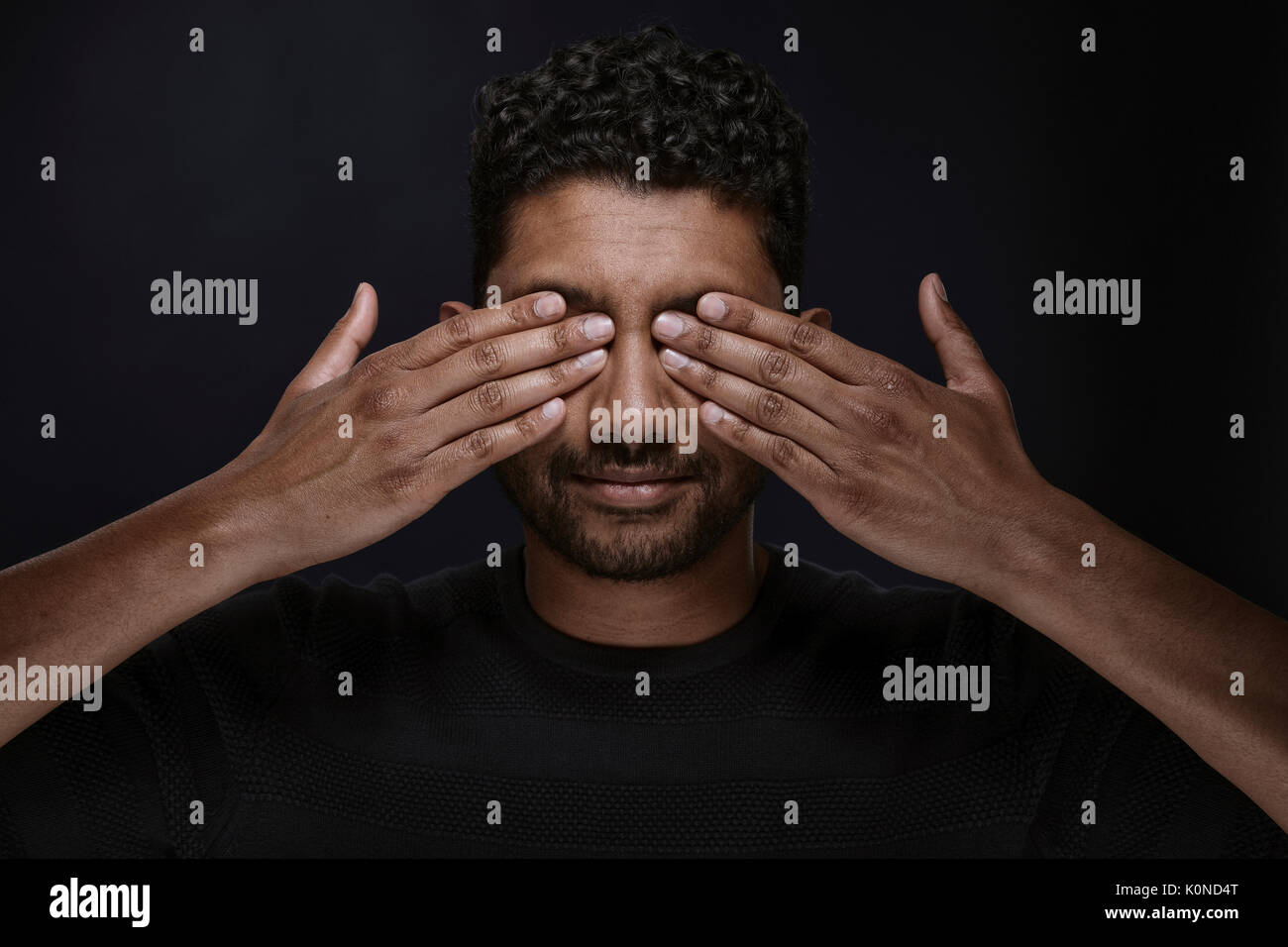 Portrait of man covering eyes with his hands Stock Photo - Alamy