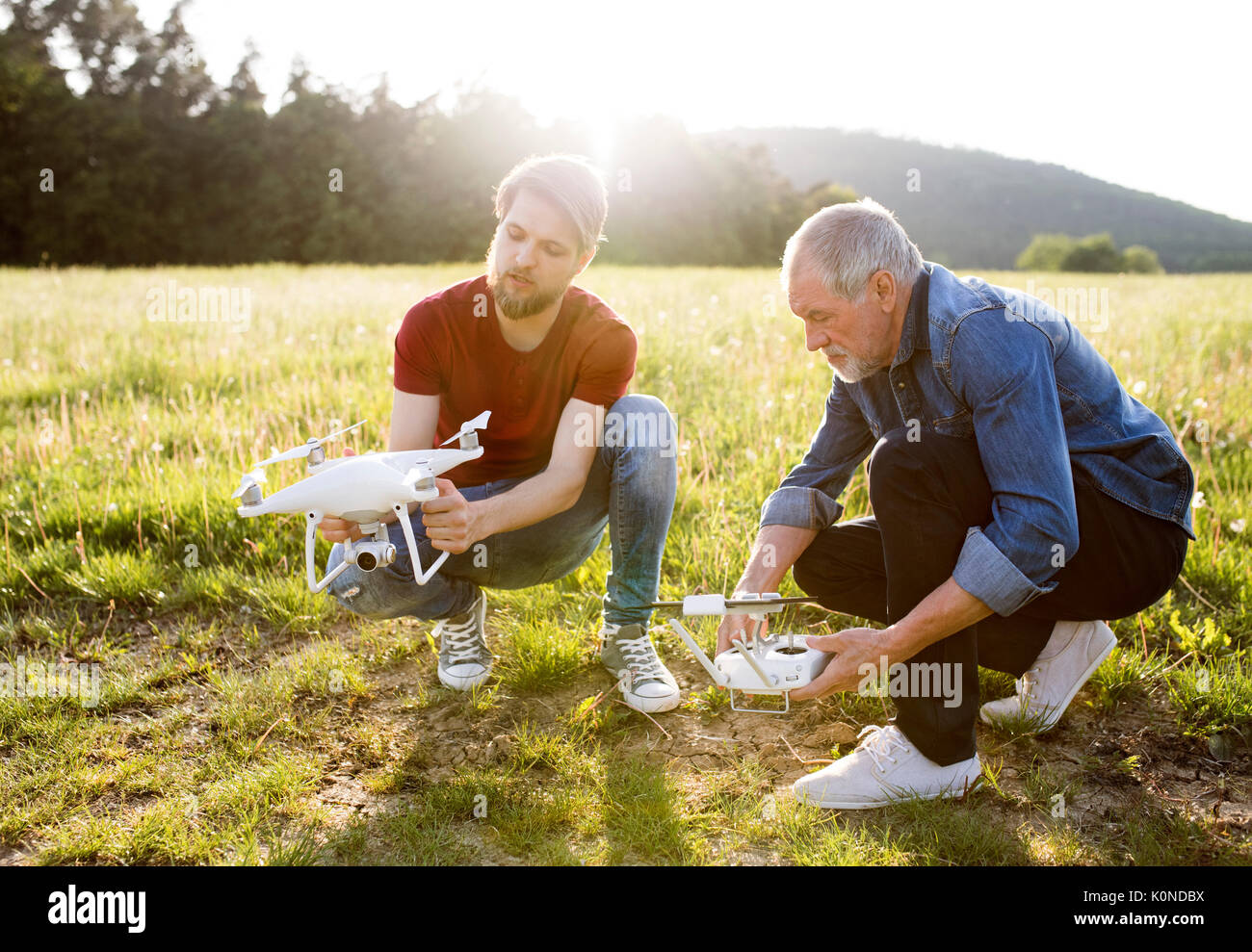 Senior father and his adult son with drone on a meadow Stock Photo - Alamy