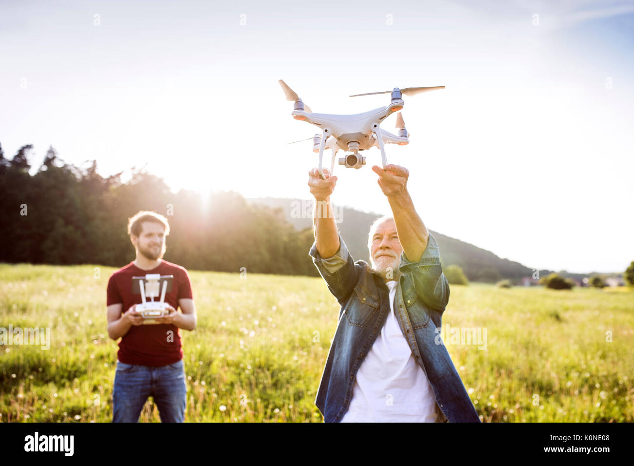 Senior father and his adult son with drone on a meadow Stock Photo - Alamy