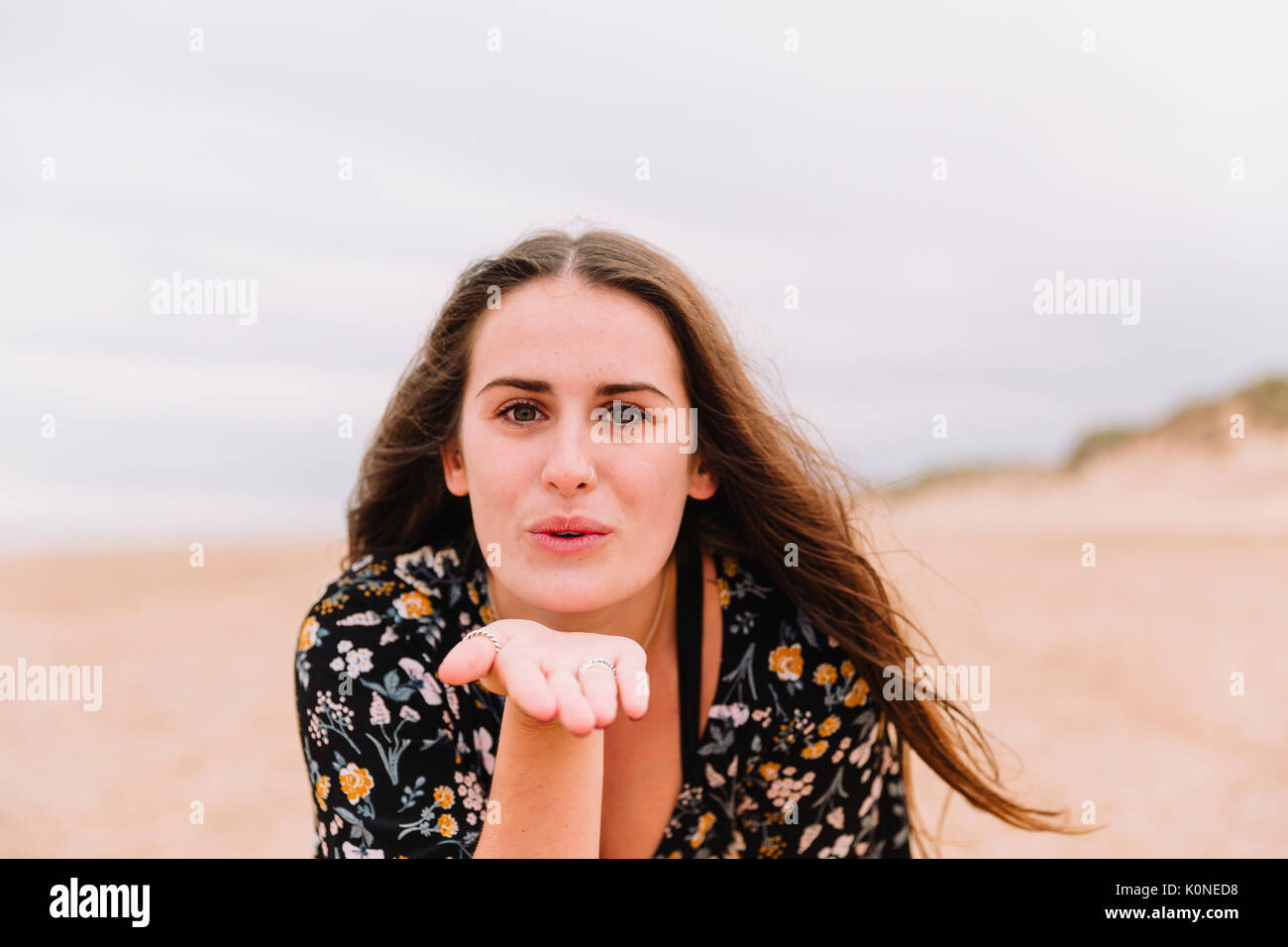 Portrait of young woman blowing kiss on the beach Stock Photo